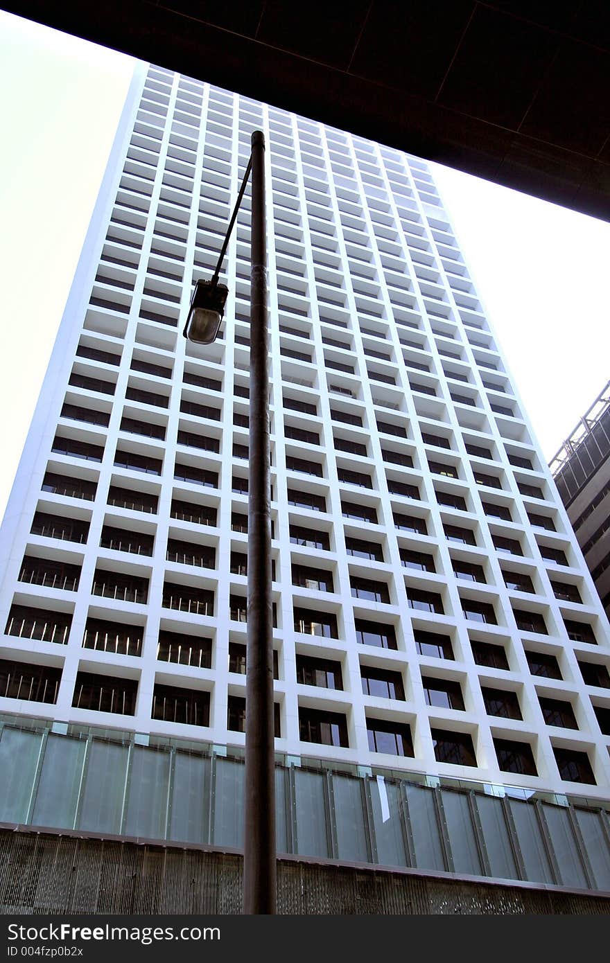 White geometric skyscraper against street lamp. White geometric skyscraper against street lamp