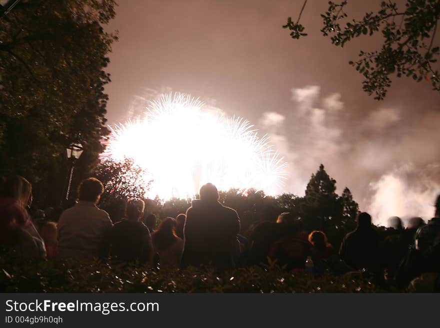 Group of people watching a firework, sitting