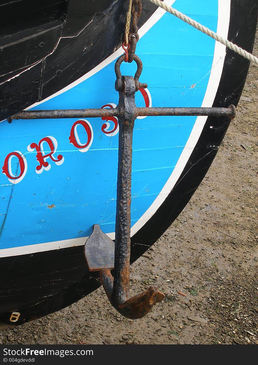 Colorful wood boat with its anchor hanging. Colorful wood boat with its anchor hanging