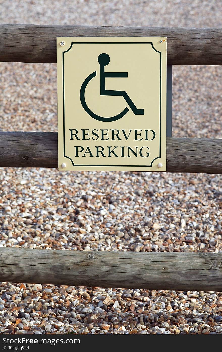 reserved parking sign for disabled drivers with gravel background.