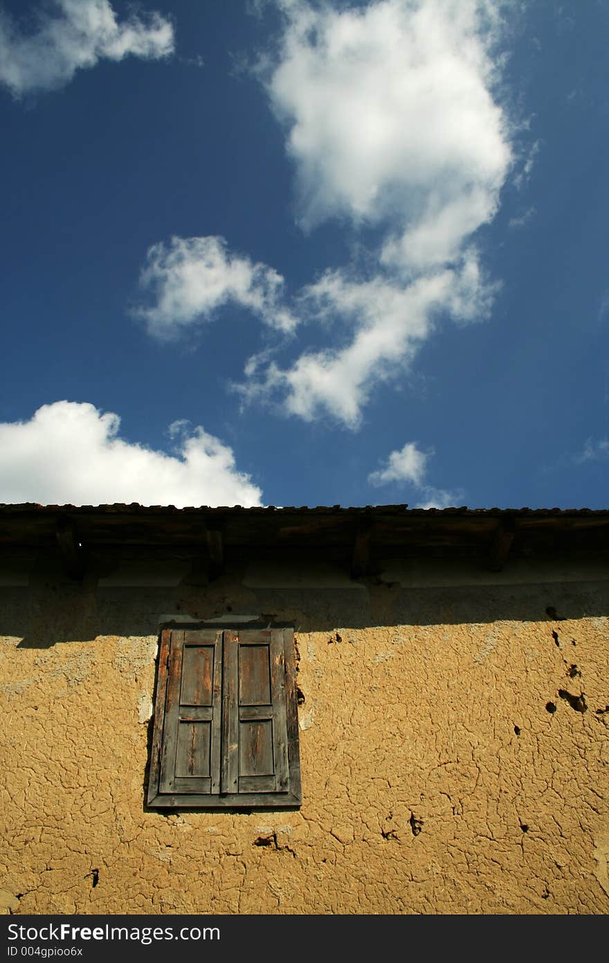 Old window against deep blue sky with clouds. Old window against deep blue sky with clouds