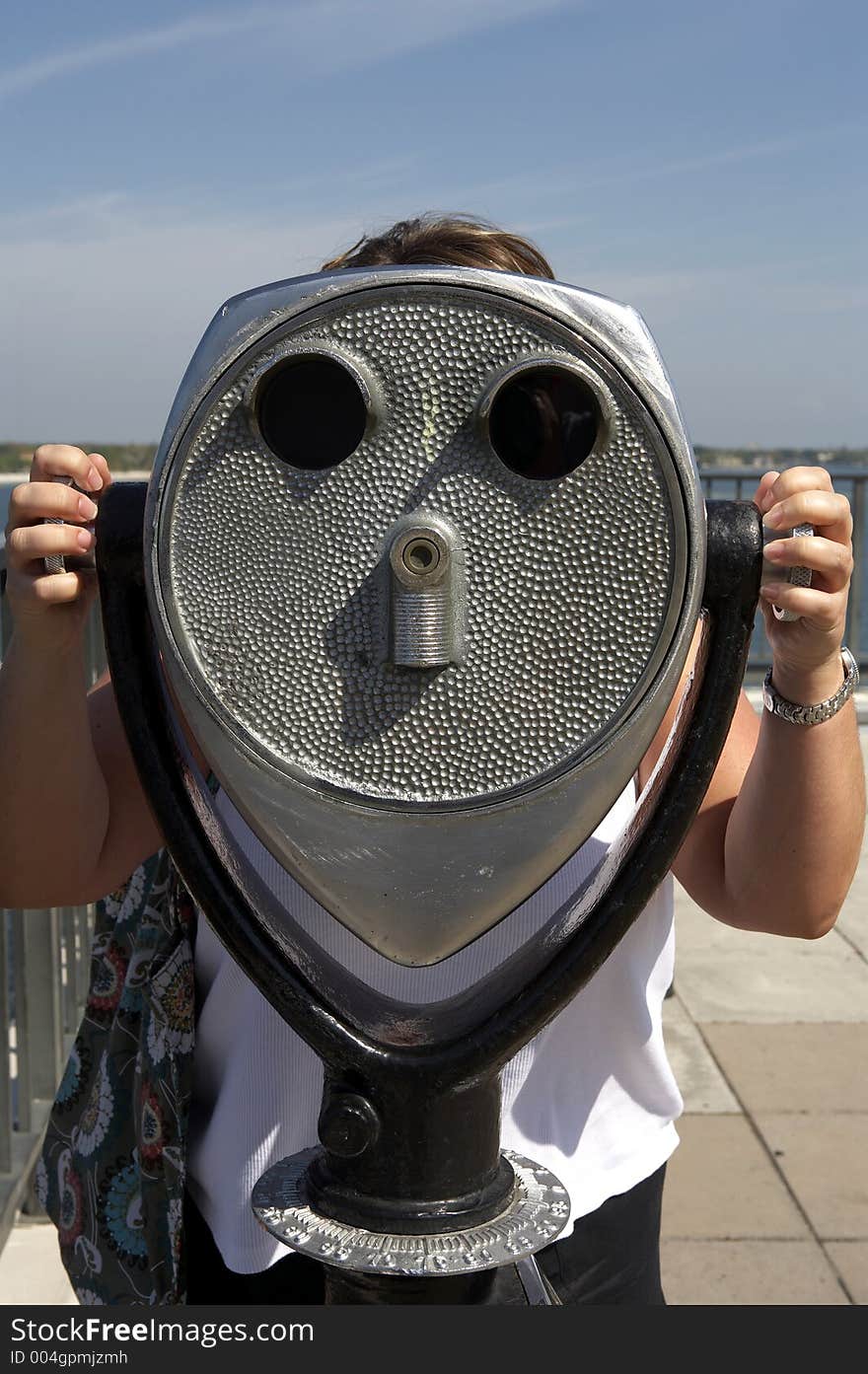 Woman Looking Through A Coin Operated Binoculars