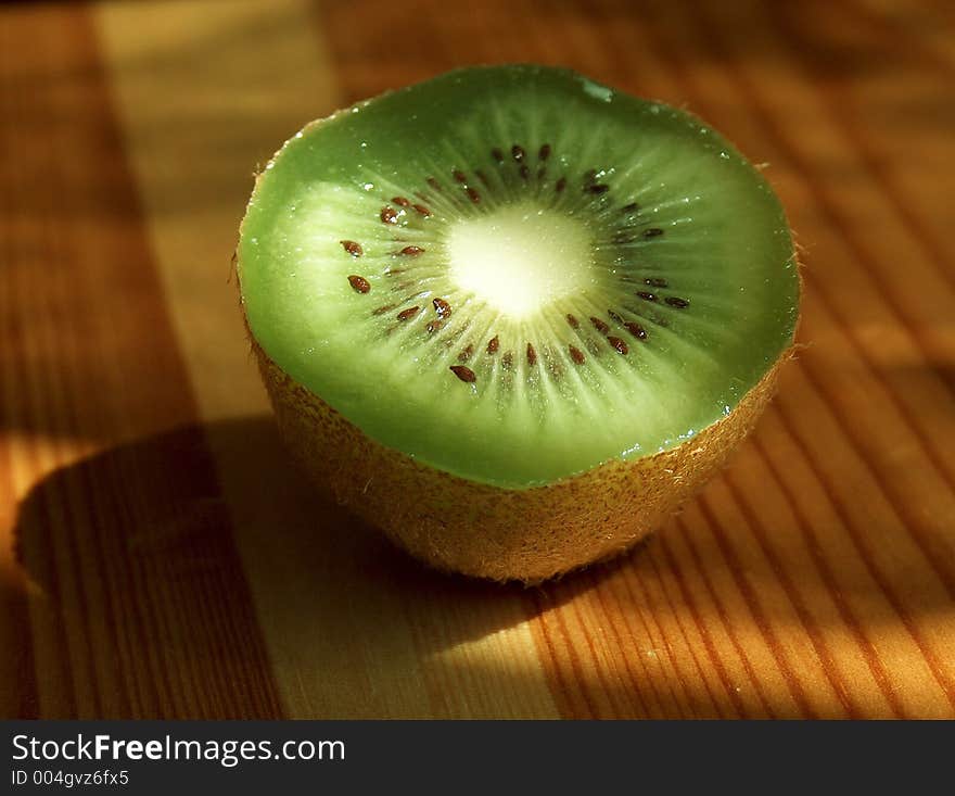 Fresh kiwi cut on half on wooden table