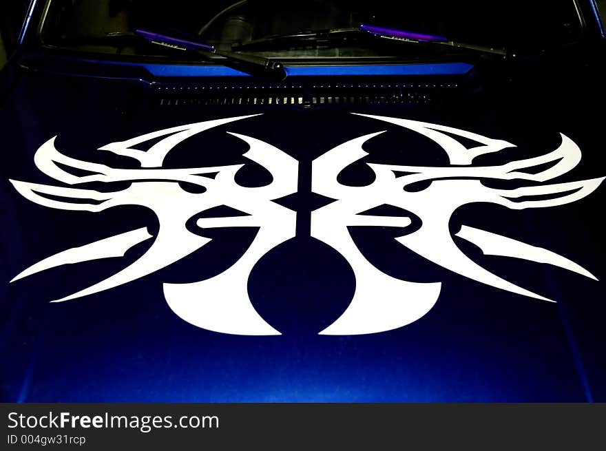 A tribal graphic on a car hood. A tribal graphic on a car hood