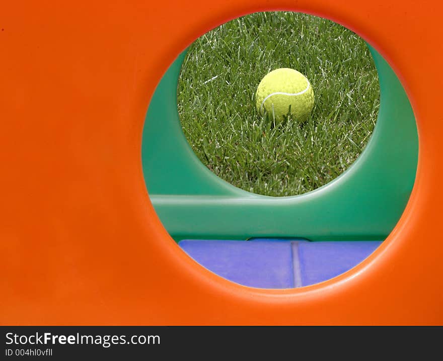 Yellow ball framed by circular holes of a child's play structure. Yellow ball framed by circular holes of a child's play structure.