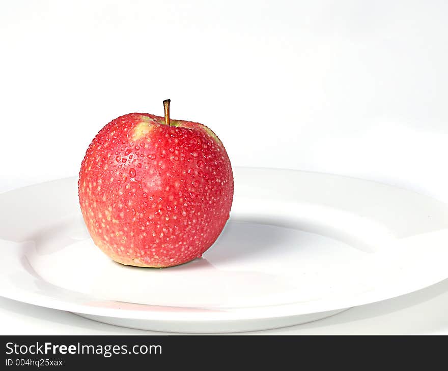 Red apple on a white plate