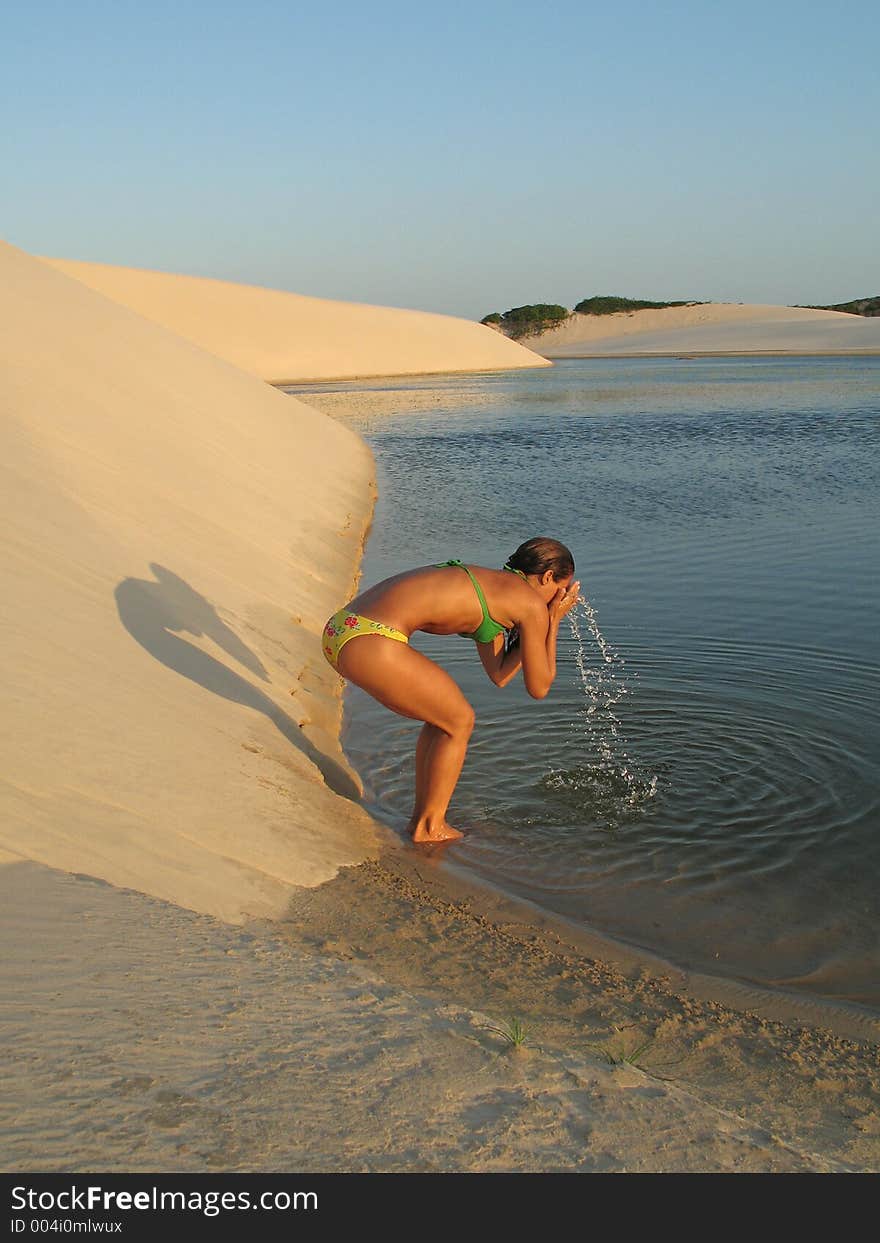 Girl washing the face in the lagoon. Girl washing the face in the lagoon.