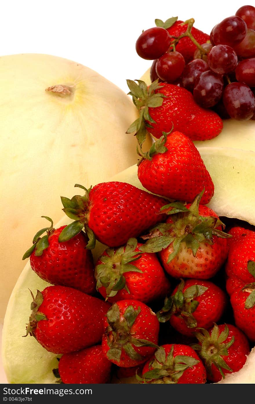 Two fresh melons with straWBERRIES AND grapes