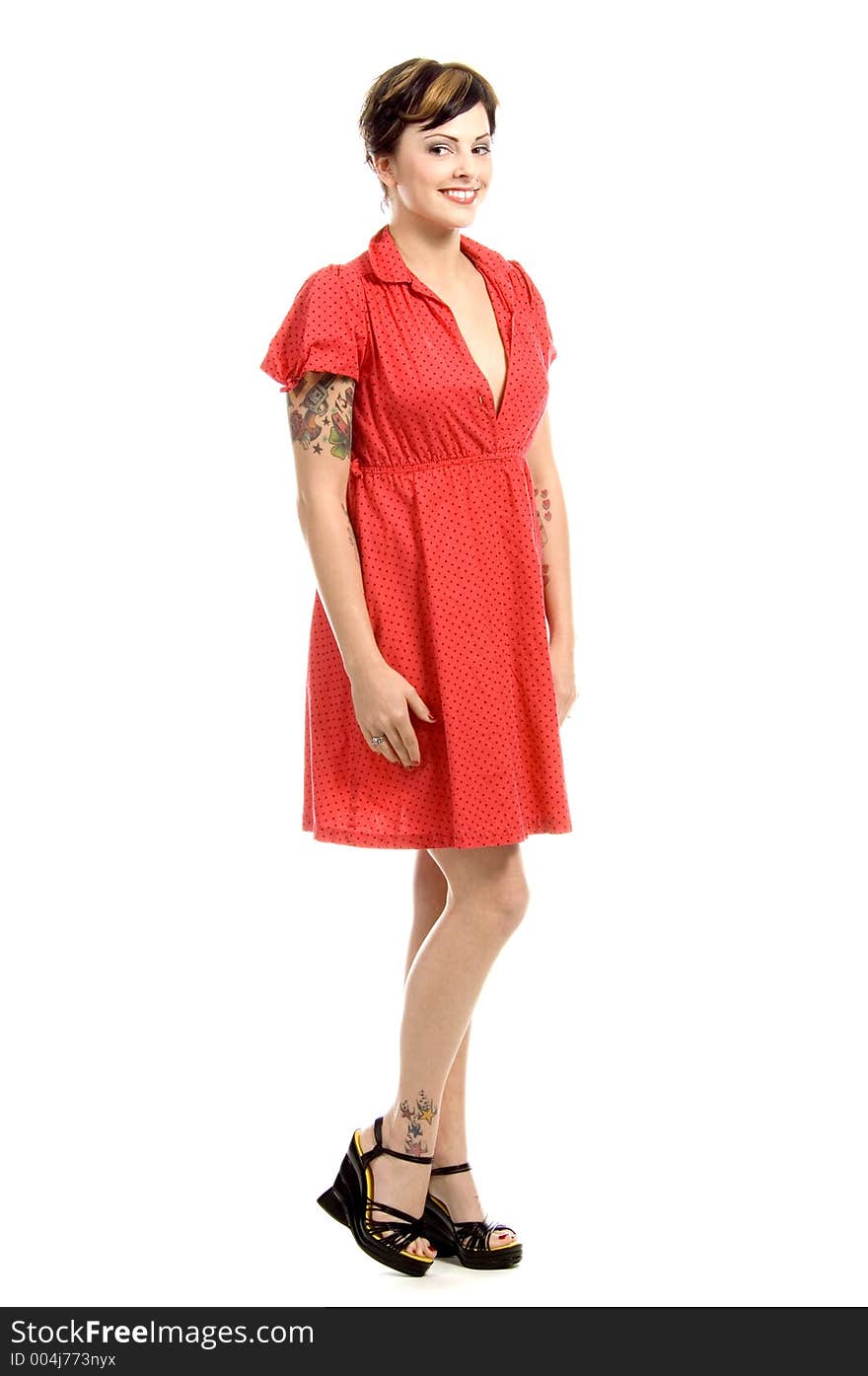 Beautiful young woman with tattoos all over and a new-age punkish hair-style, dressed in a bright red dress, in a cross-culture combination. Beautiful young woman with tattoos all over and a new-age punkish hair-style, dressed in a bright red dress, in a cross-culture combination