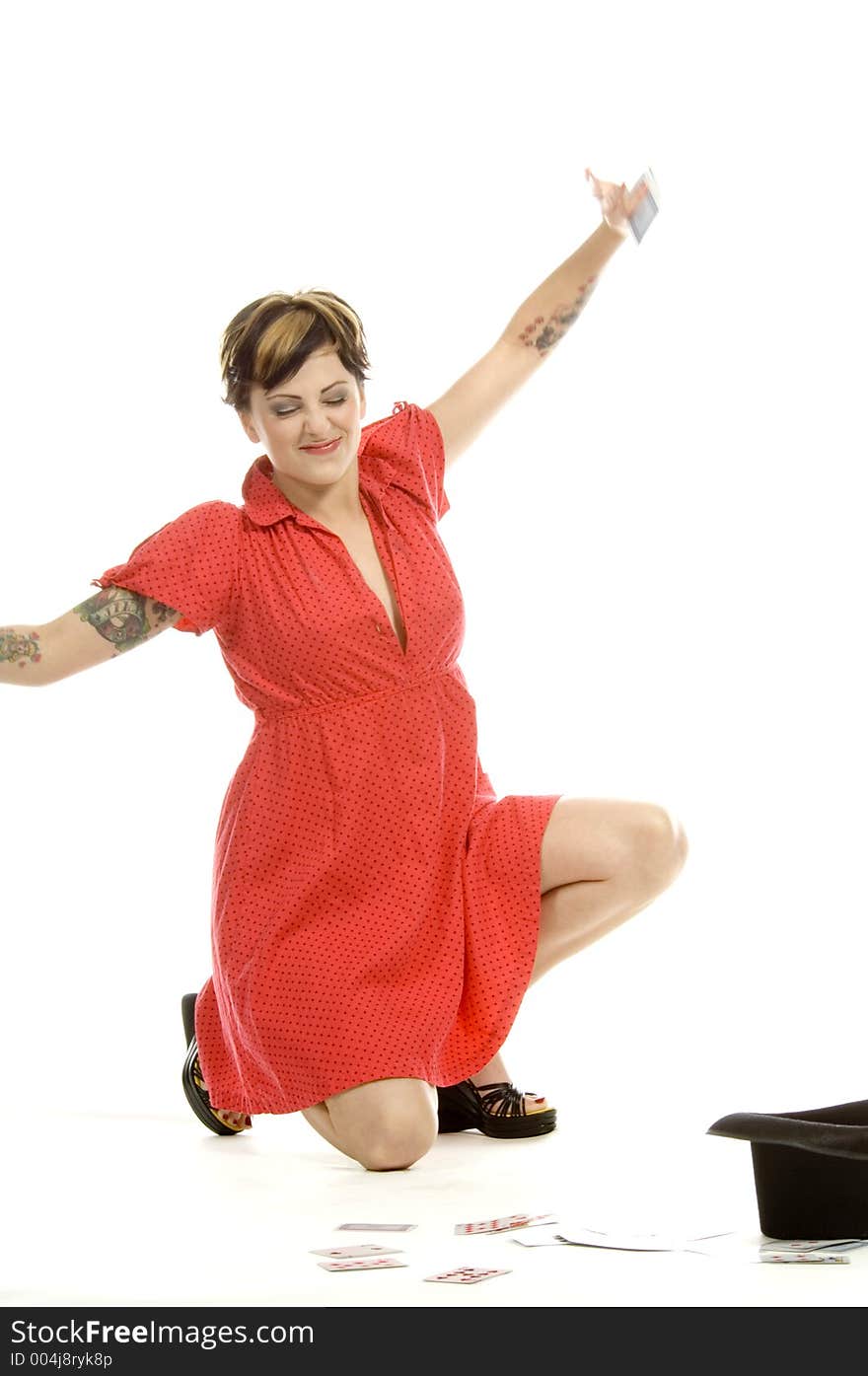 young actress with tattoos, a red girlish dress, poses different postures and expressions for an audition, with playing cards and a big black hat, over a white background. young actress with tattoos, a red girlish dress, poses different postures and expressions for an audition, with playing cards and a big black hat, over a white background