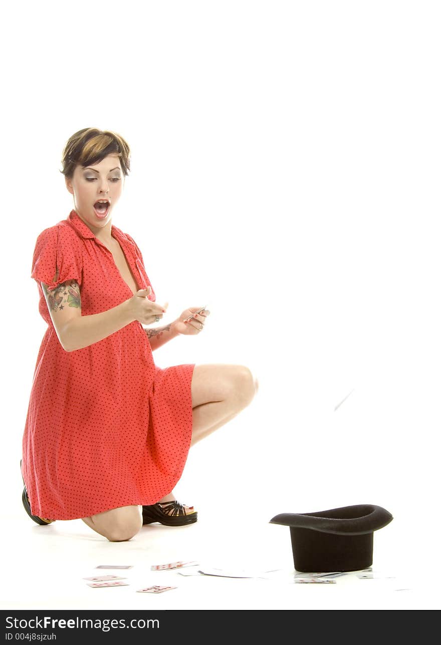 young actress with tattoos, a red girlish dress, poses different postures and expressions for an audition, with playing cards and a big black hat, over a white background. young actress with tattoos, a red girlish dress, poses different postures and expressions for an audition, with playing cards and a big black hat, over a white background