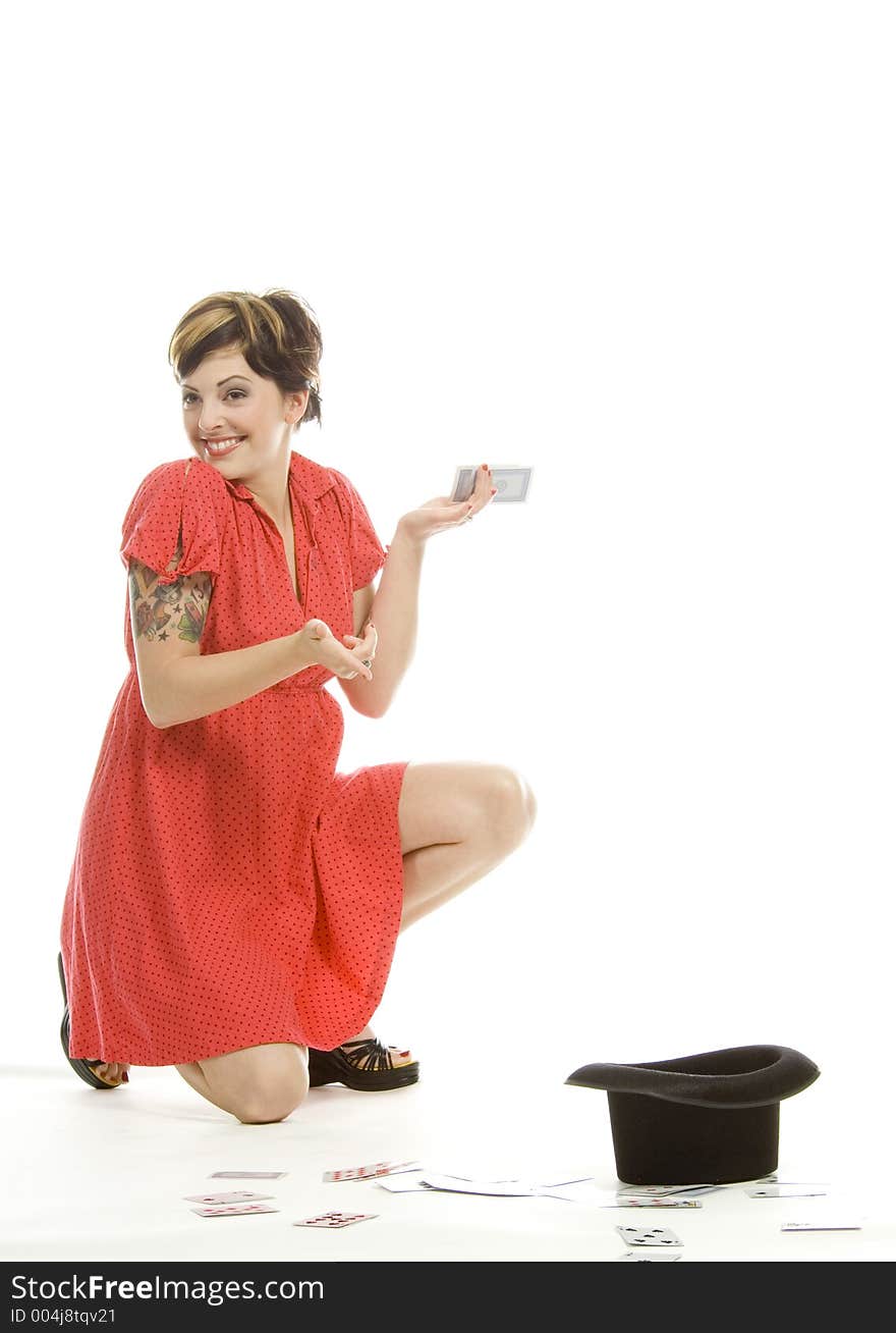 young actress with tattoos, a red girlish dress, poses different postures and expressions for an audition, with playing cards and a big black hat, over a white background. young actress with tattoos, a red girlish dress, poses different postures and expressions for an audition, with playing cards and a big black hat, over a white background