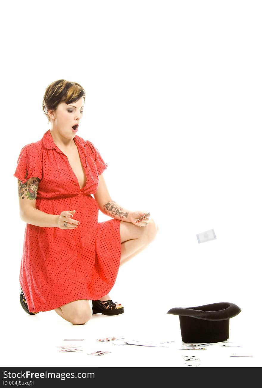 young actress with tattoos, a red girlish dress, poses different postures and expressions for an audition, with playing cards and a big black hat, over a white background. young actress with tattoos, a red girlish dress, poses different postures and expressions for an audition, with playing cards and a big black hat, over a white background