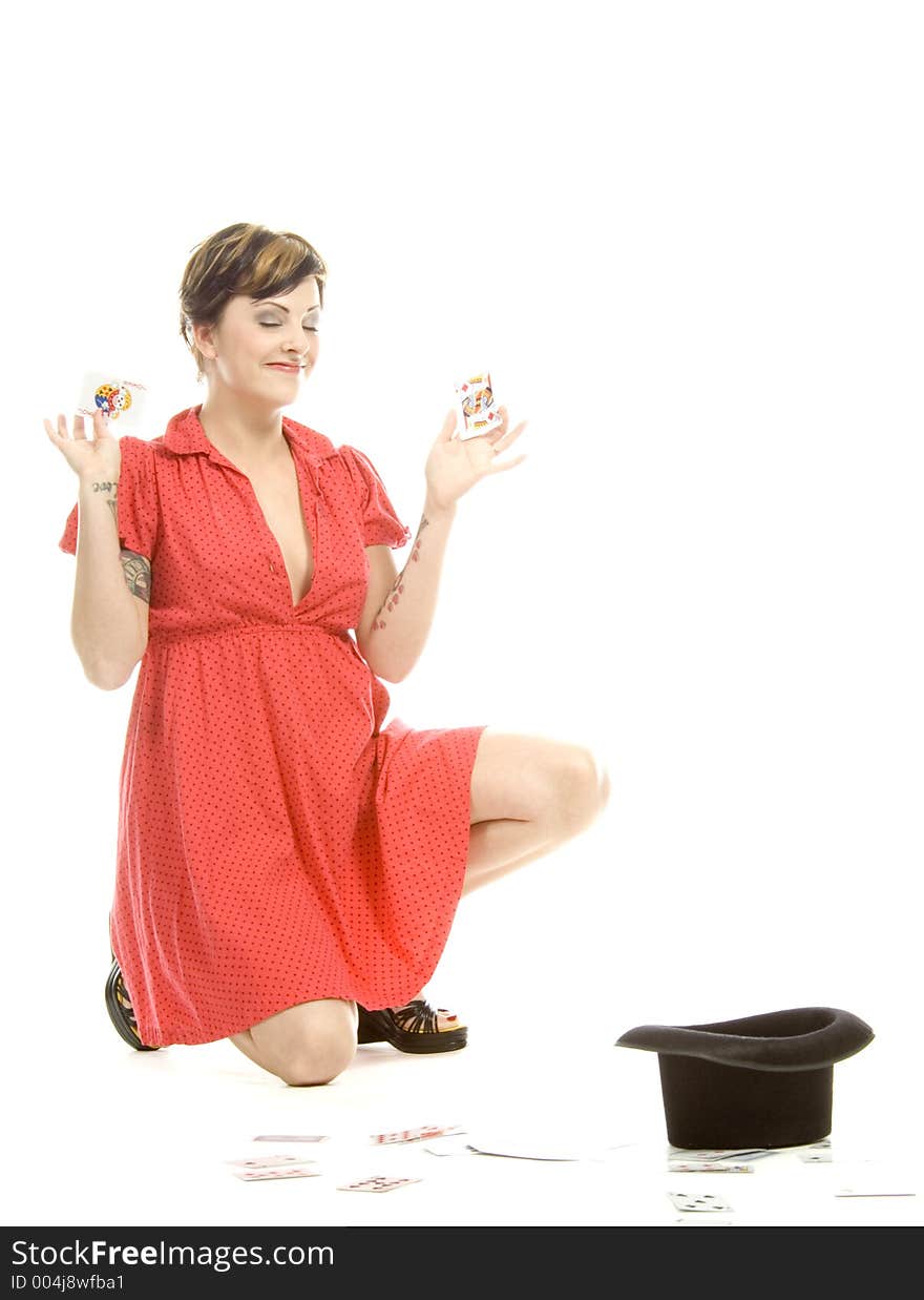 young actress with tattoos, a red girlish dress, poses different postures and expressions for an audition, with playing cards and a big black hat, over a white background. young actress with tattoos, a red girlish dress, poses different postures and expressions for an audition, with playing cards and a big black hat, over a white background