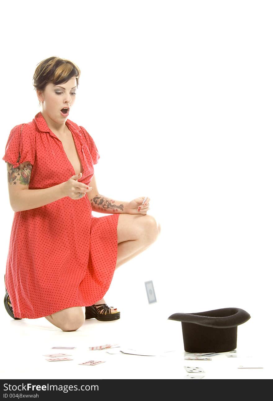 young actress with tattoos, a red girlish dress, poses different postures and expressions for an audition, with playing cards and a big black hat, over a white background. young actress with tattoos, a red girlish dress, poses different postures and expressions for an audition, with playing cards and a big black hat, over a white background