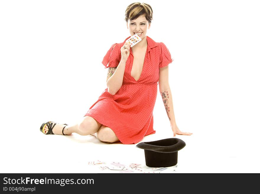 young actress with tattoos, a red girlish dress, poses different postures and expressions for an audition, with playing cards and a big black hat, over a white background. young actress with tattoos, a red girlish dress, poses different postures and expressions for an audition, with playing cards and a big black hat, over a white background