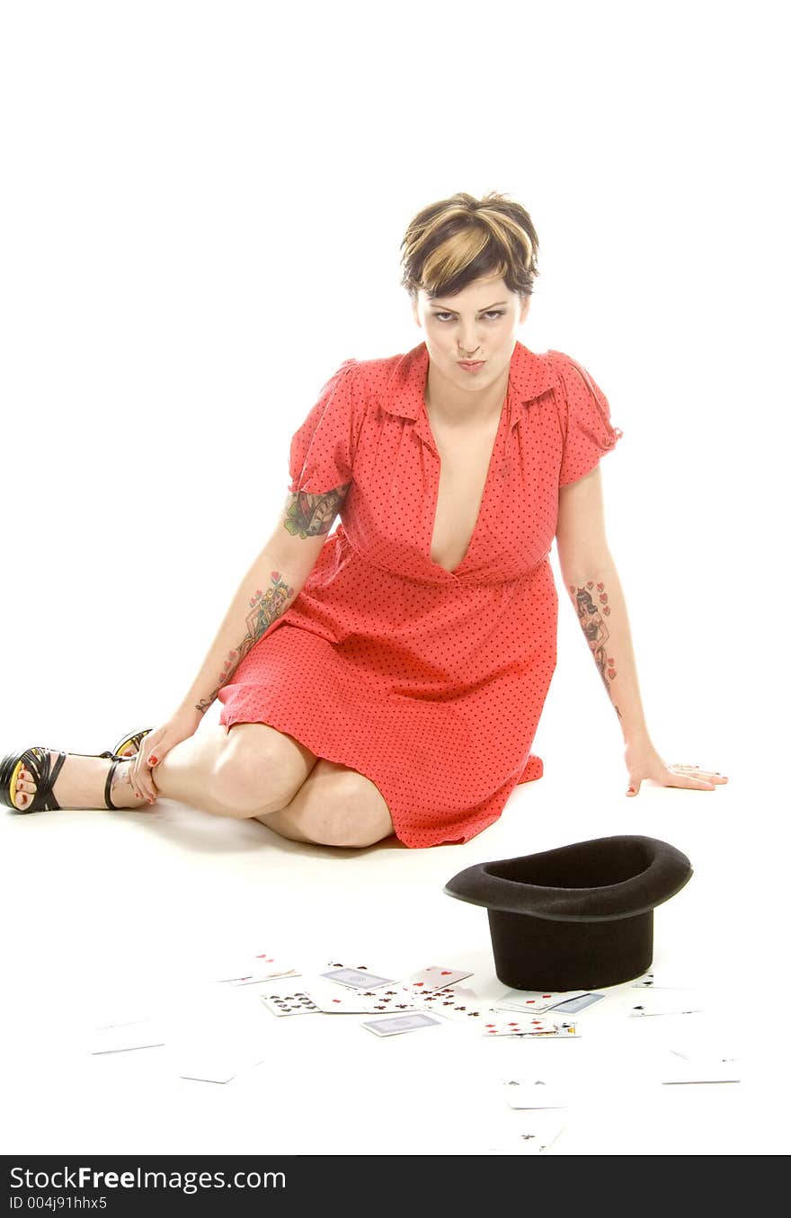 young actress with tattoos, a red girlish dress, poses different postures and expressions for an audition, with playing cards and a big black hat, over a white background. young actress with tattoos, a red girlish dress, poses different postures and expressions for an audition, with playing cards and a big black hat, over a white background