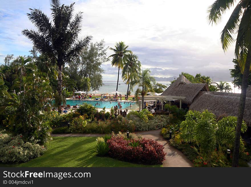 Tropical ressort and pool with people and palm trees