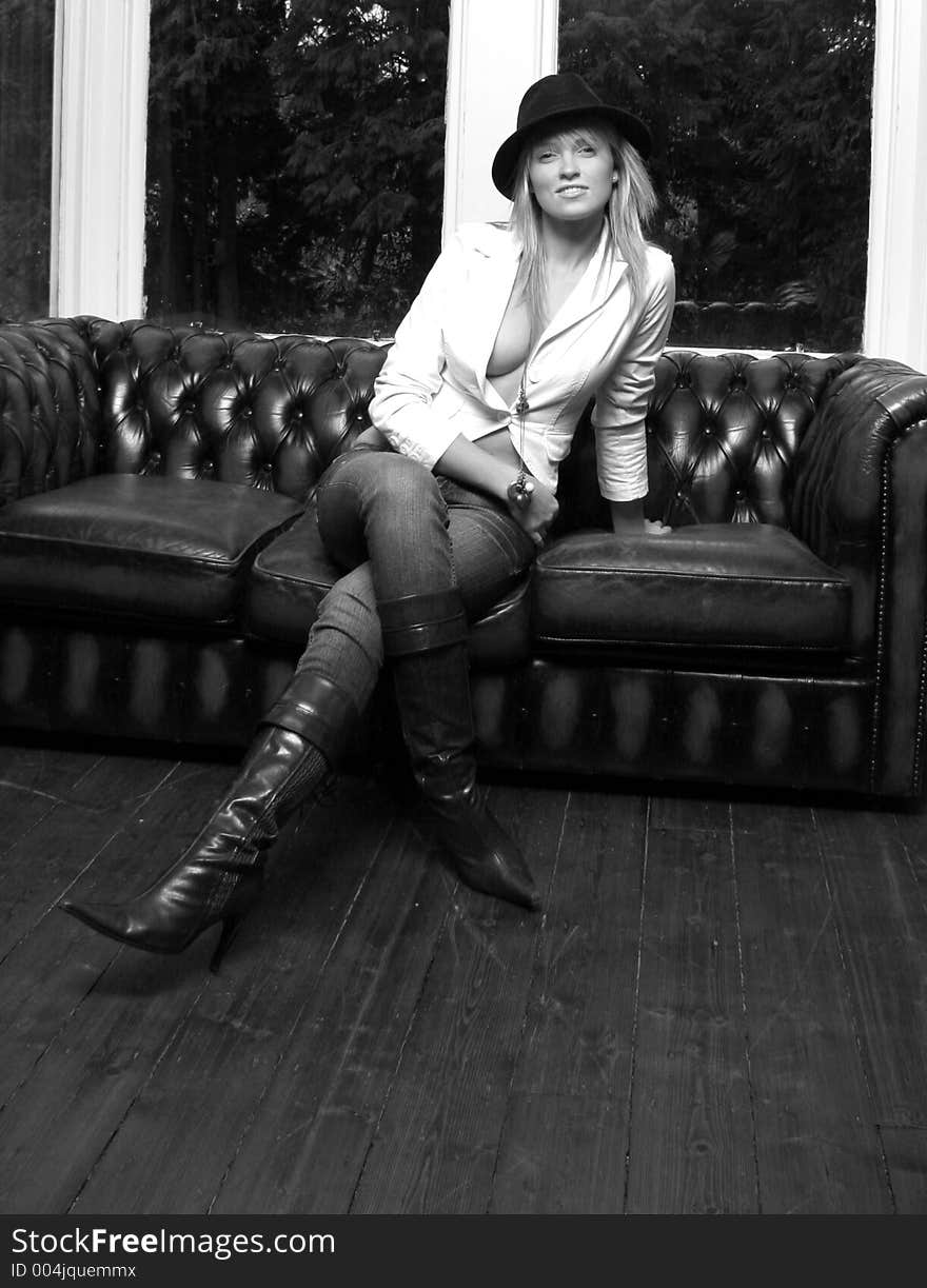 model wearing leather boots on a leather sofa. model wearing leather boots on a leather sofa