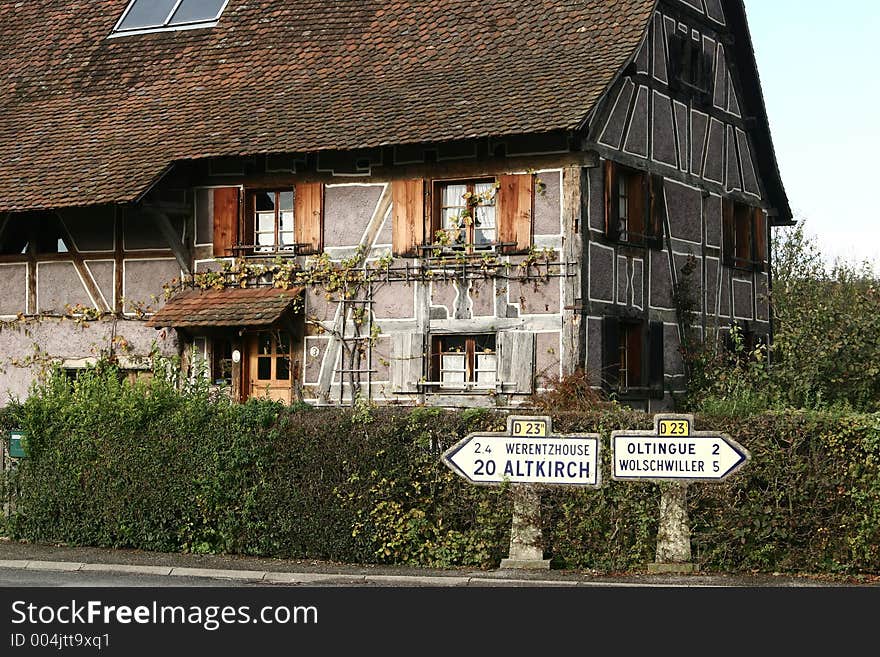 In the street of a alsacian villlage in the summer, signs with village names. In the street of a alsacian villlage in the summer, signs with village names