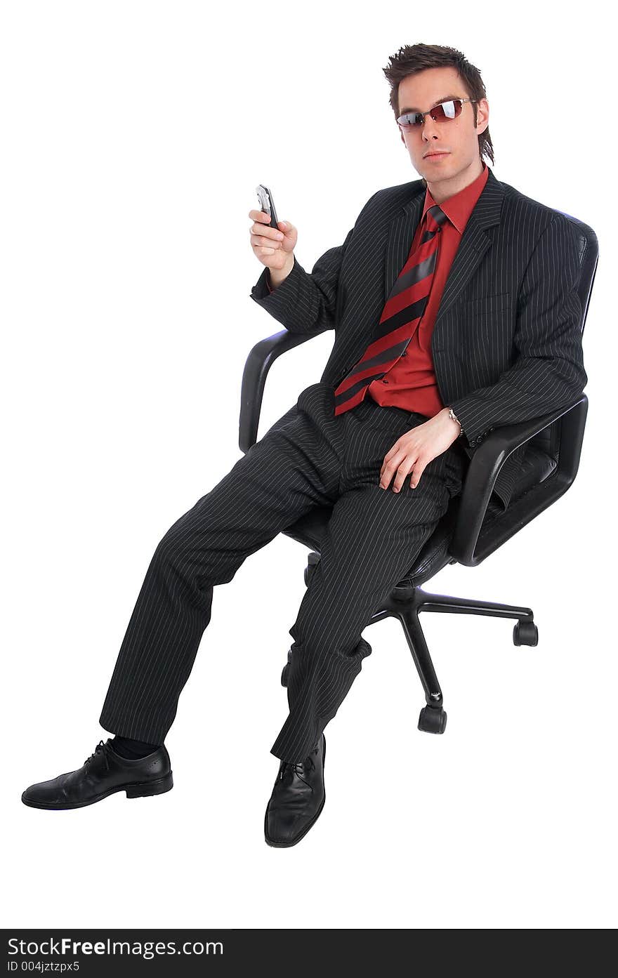 Businessman sits in chair holding a mobile phone and wearing cool shades