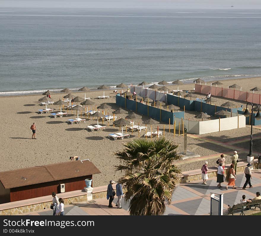 Beach scene with parasols and sunbeds