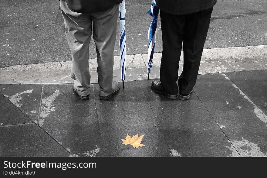 Image of two people with raincoats and a fallen leaf depicting cooler weather has arrived. Image of two people with raincoats and a fallen leaf depicting cooler weather has arrived