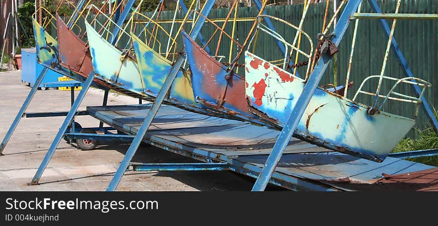 Children's boat swings un line awaiting painting. Children's boat swings un line awaiting painting