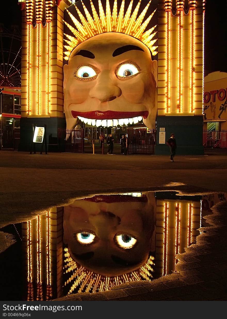 Image of a them park entrance and it's reflection in a puddle, depicting double the fun...perhaps!. Image of a them park entrance and it's reflection in a puddle, depicting double the fun...perhaps!