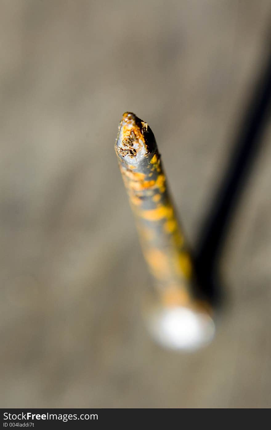 Abstract blurred close up of pointed end of rusty nail