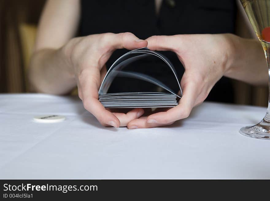 Close-up shot on a woman's hands shuffling the cards during a poker game