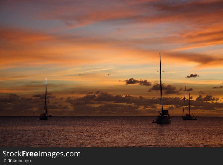 Colourful caribbean sunset with sailboats. Colourful caribbean sunset with sailboats