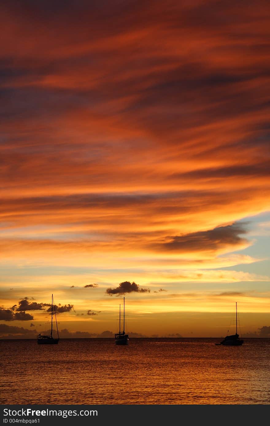 Colourful caribbean sunset with sailboats. Colourful caribbean sunset with sailboats