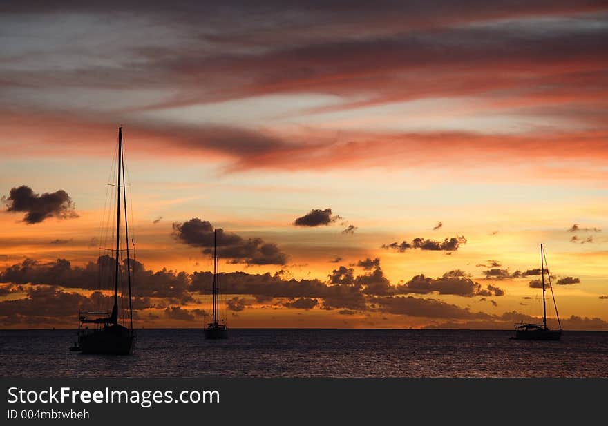 Colourful caribbean sunset with sailboats. Colourful caribbean sunset with sailboats