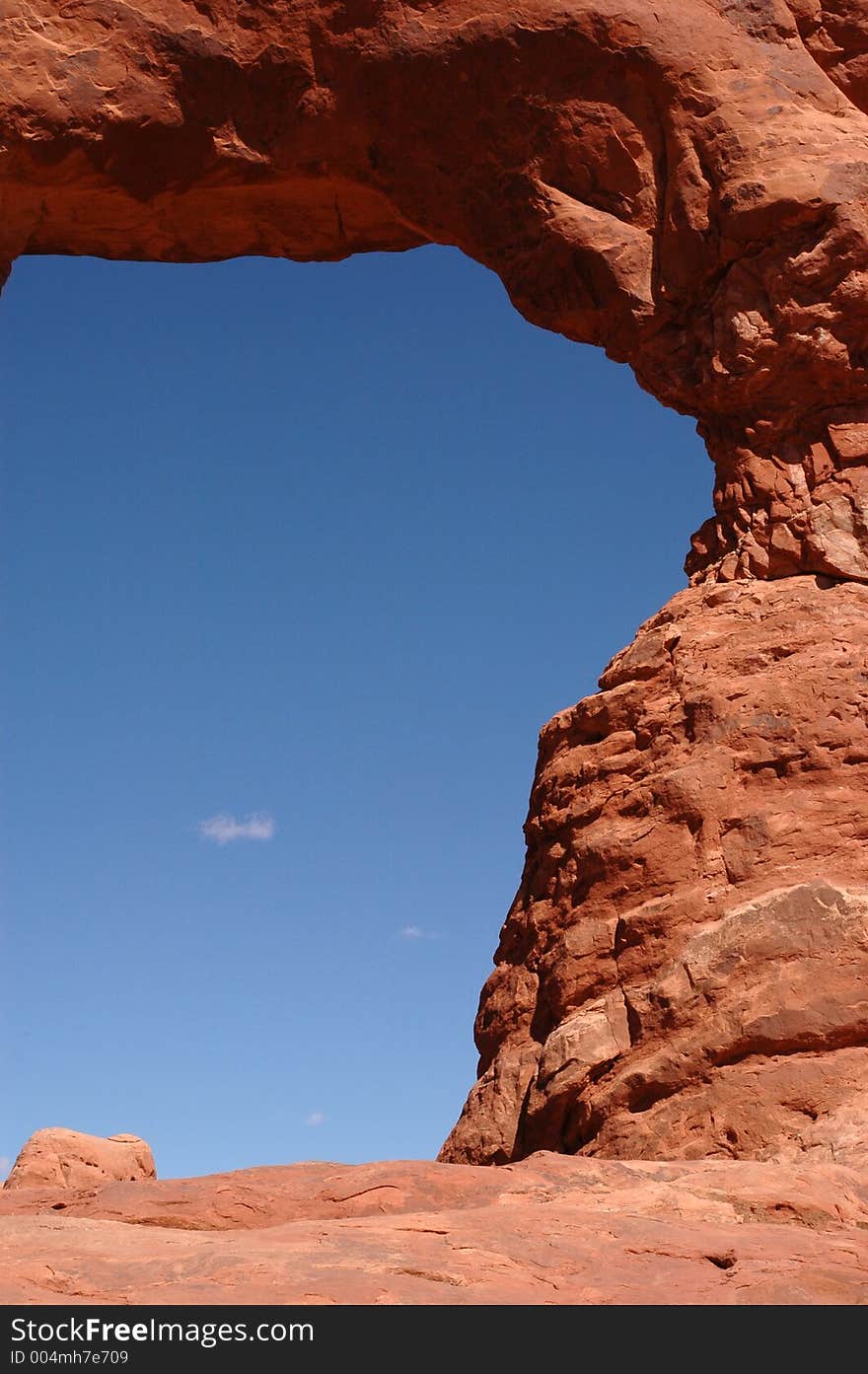 Cropped close up of a natural stone arch with blue sky showing through. Arches National Park, Utah, USA.