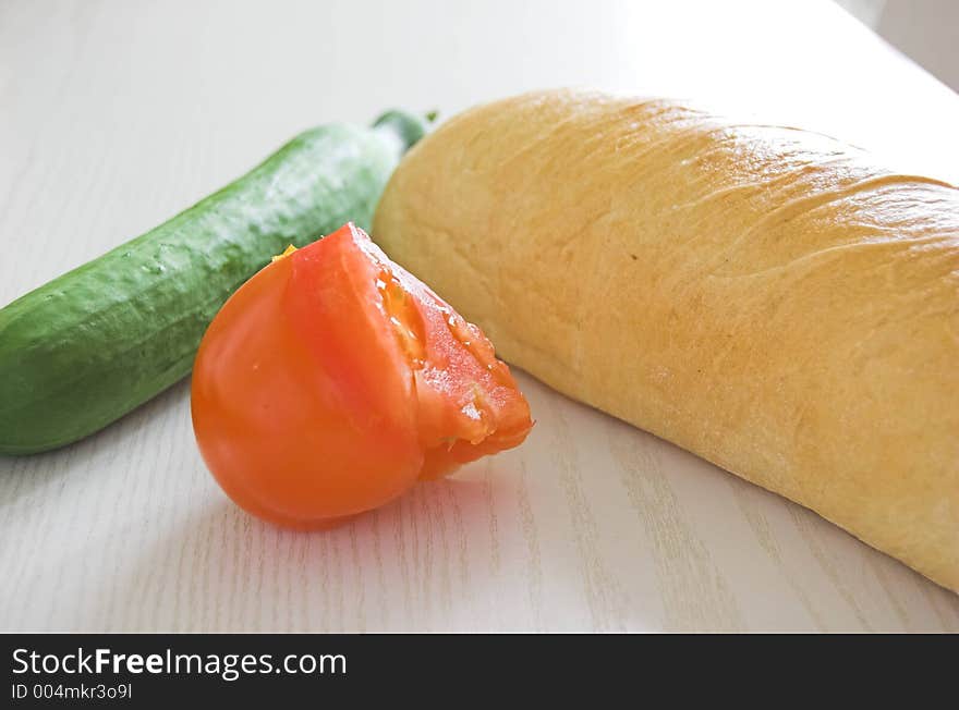 Vegetables and bread on the table in kitchen. Vegetables and bread on the table in kitchen