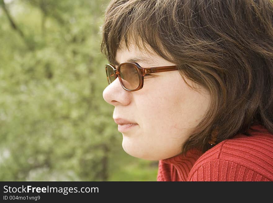 Woman looking to the left side of the image with nature in the background. Woman looking to the left side of the image with nature in the background