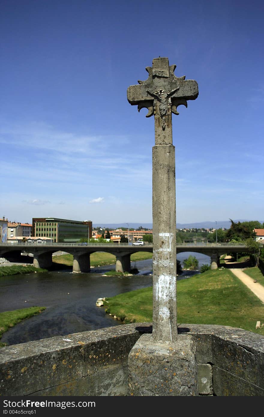 Stone cross on bridge in town of carcassonne, france