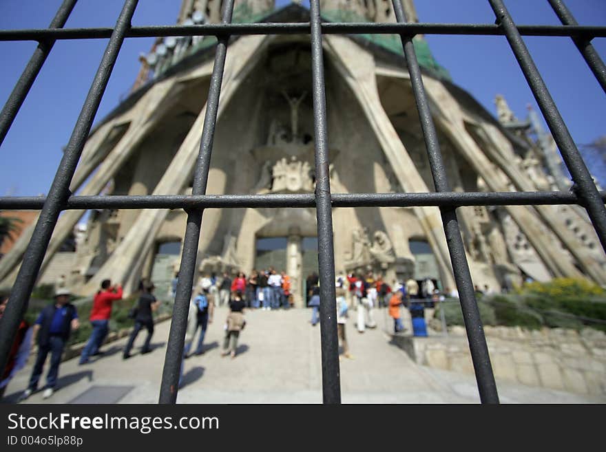 Gaudi's famous sagrada familia church in barcelona seen through iron gate