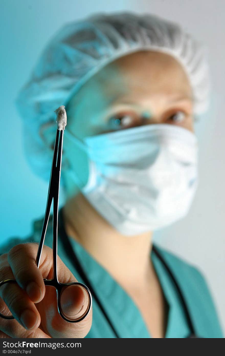 Female doctor/surgeon in scrubs with hemostat. Female doctor/surgeon in scrubs with hemostat