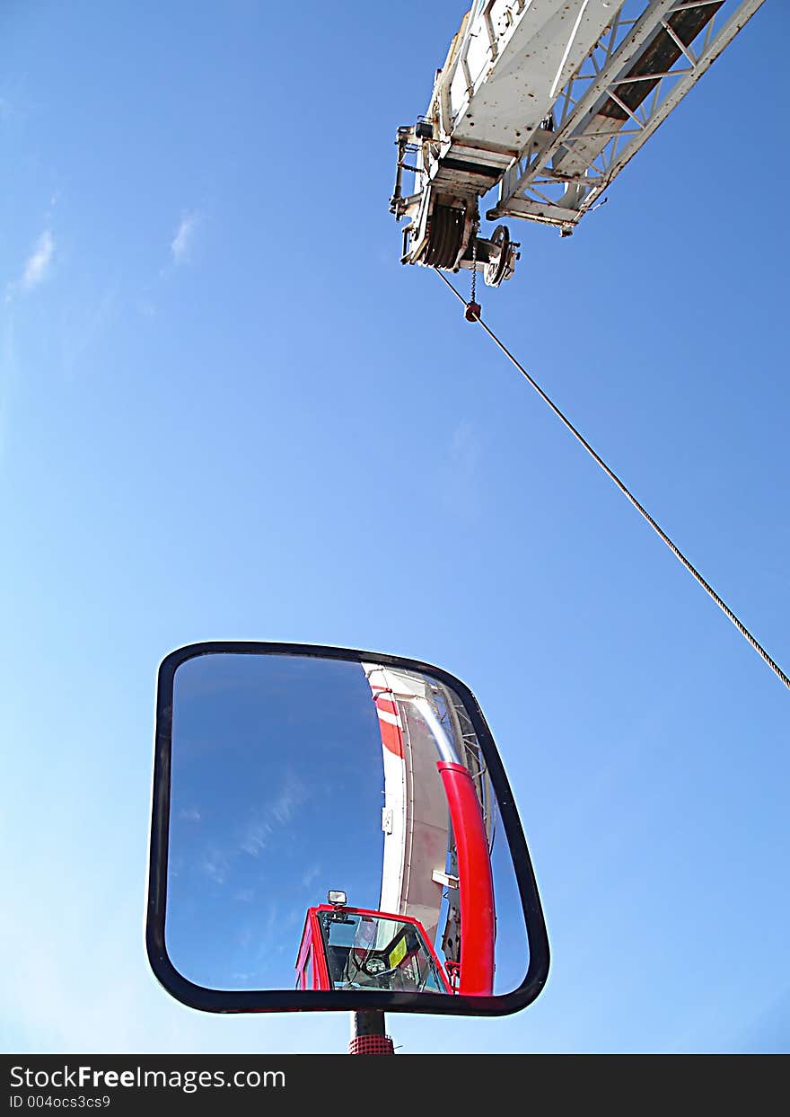 Construction crane's reflection in it's own mirror with it's arm in the air. Construction crane's reflection in it's own mirror with it's arm in the air.