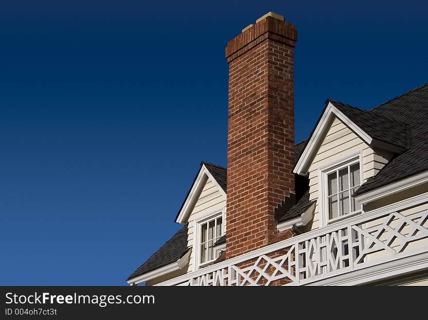 A brick chimney rises between two roof windows. A brick chimney rises between two roof windows.