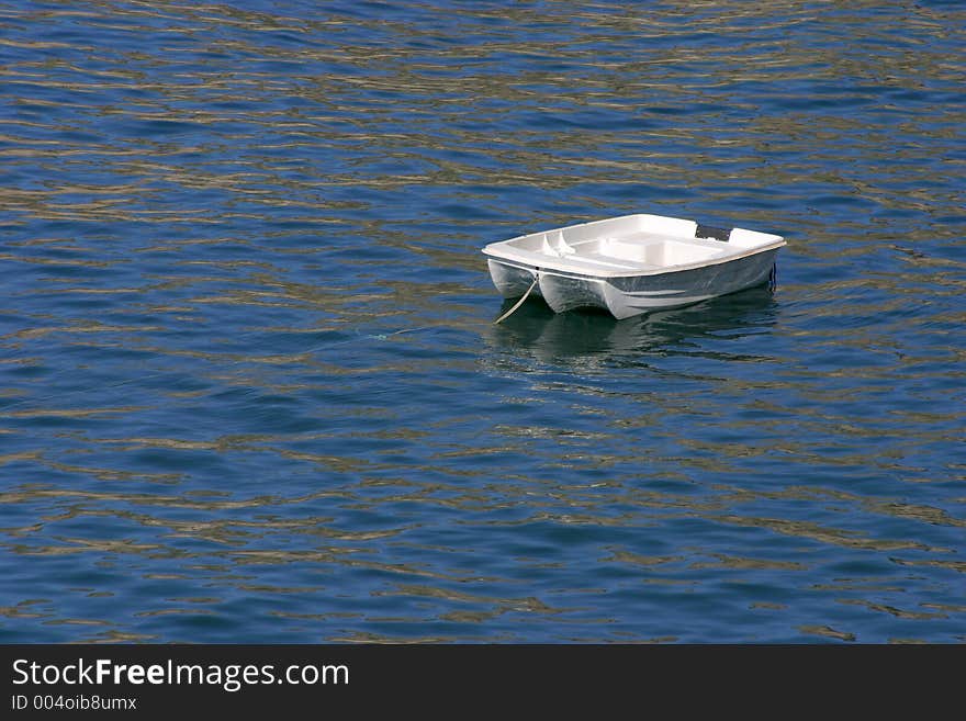 A small dingy bobs in the waters of the Pacific Ocean. A small dingy bobs in the waters of the Pacific Ocean.