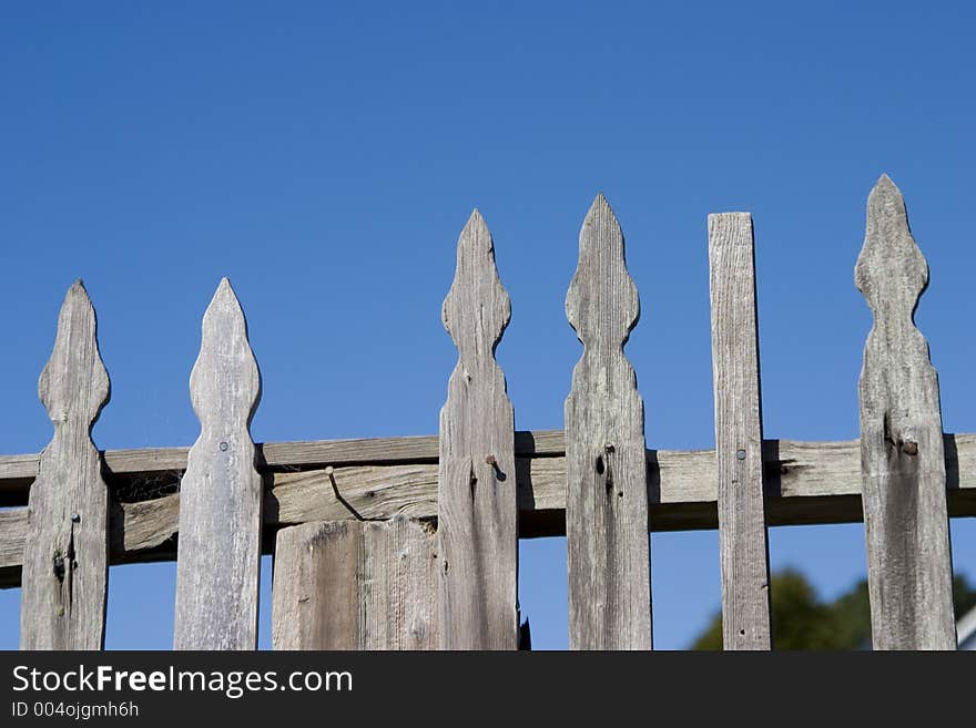 A rustic picket, fence in a small town. A rustic picket, fence in a small town.