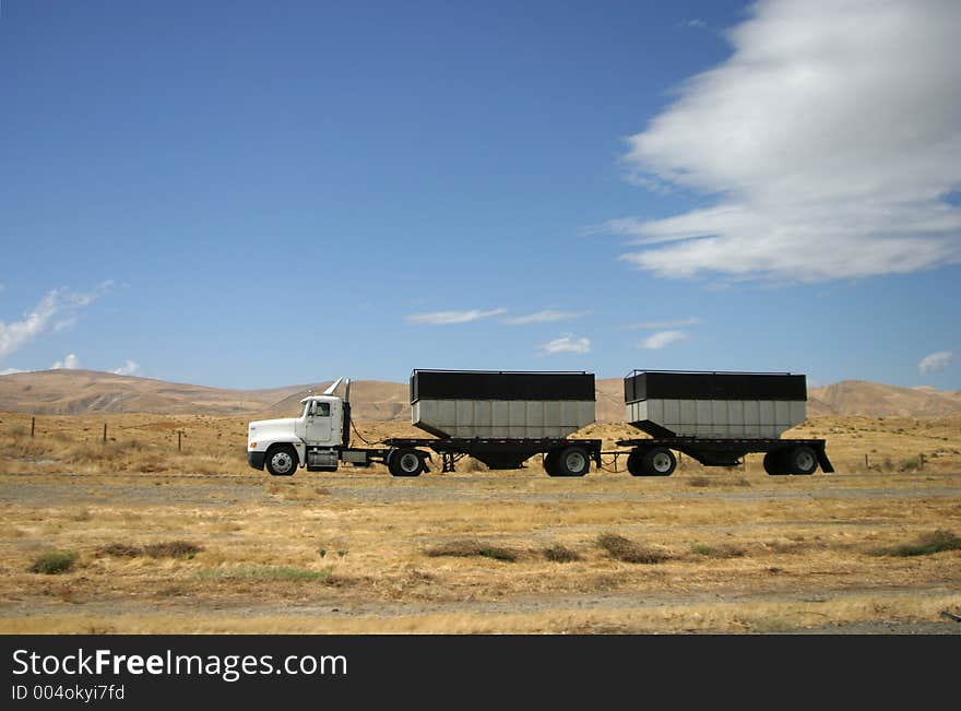 A tractor-trailer hauls some stuff down the highway. A tractor-trailer hauls some stuff down the highway.