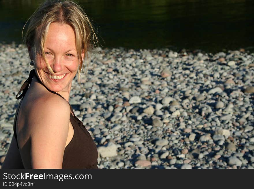 A girl smiles against a smooth rock background. A girl smiles against a smooth rock background.