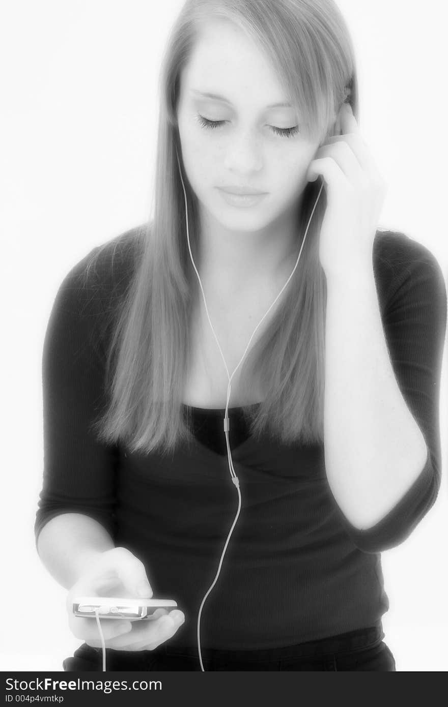 Black and white teen girl listening to digital music player.