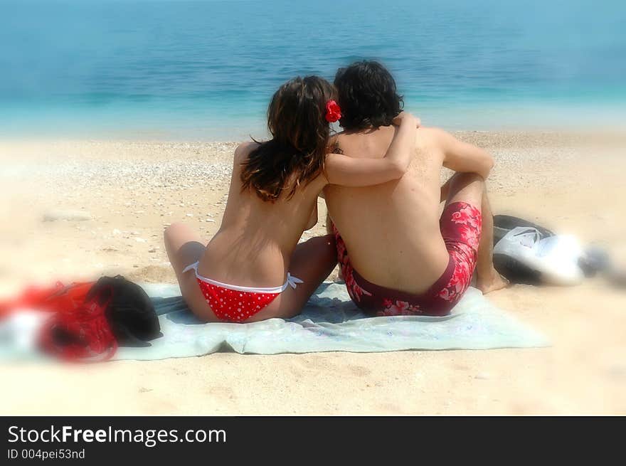 A cute couple cuddles on an italian beach