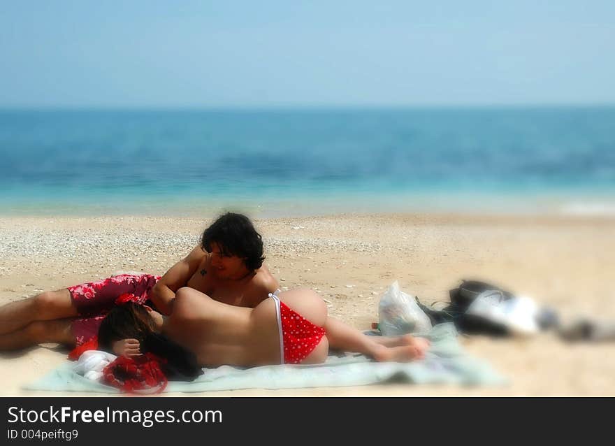 A cute couple cuddles on an italian beach