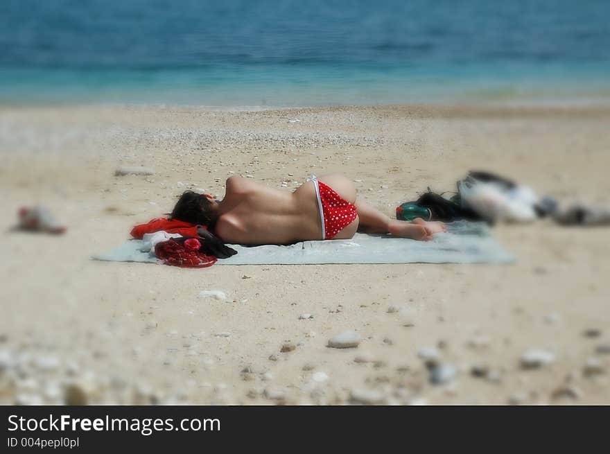 Topless babe takes a nap on the beach